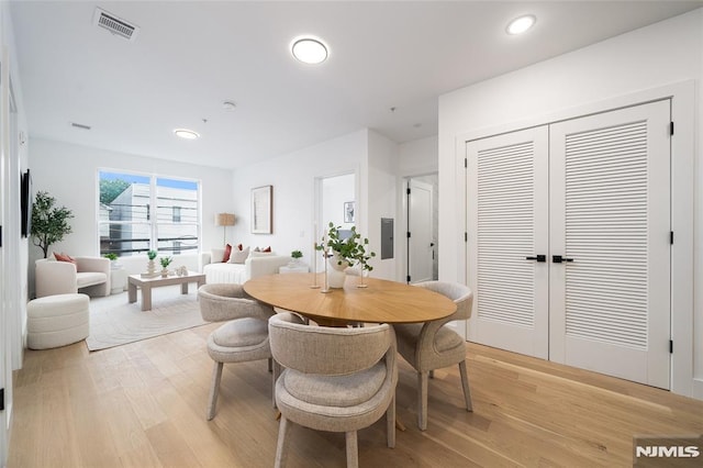 dining space featuring electric panel and light wood-type flooring