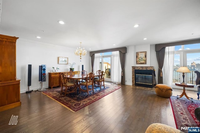 dining room with an inviting chandelier, a fireplace, dark wood-type flooring, and ornamental molding