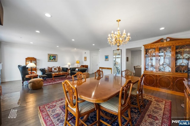 dining room with crown molding, dark hardwood / wood-style floors, and a chandelier