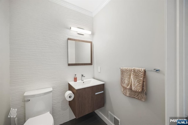 bathroom featuring ornamental molding, toilet, and vanity