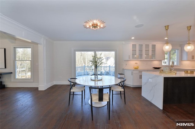 dining area featuring dark hardwood / wood-style flooring, sink, and crown molding