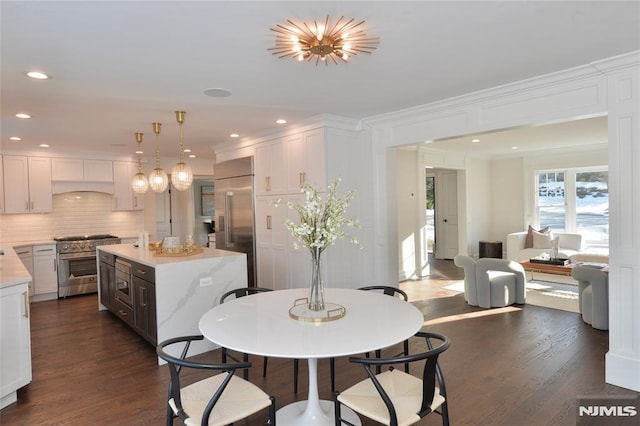 dining room with dark wood-type flooring and ornamental molding