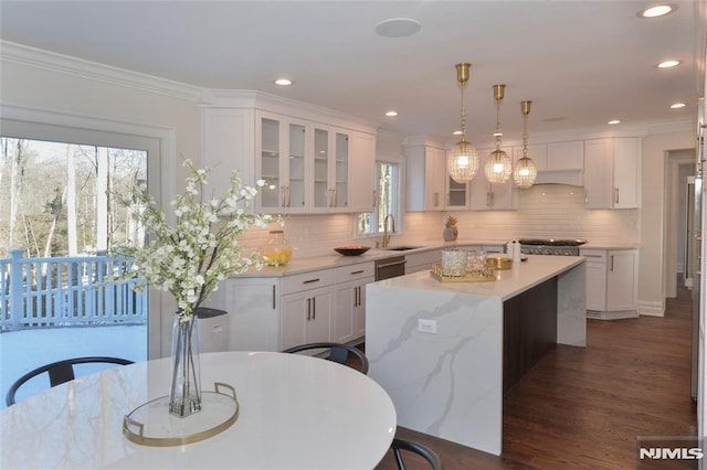 kitchen featuring sink, decorative light fixtures, a center island, dark hardwood / wood-style floors, and white cabinets