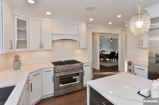 kitchen featuring pendant lighting, high end stove, and white cabinets