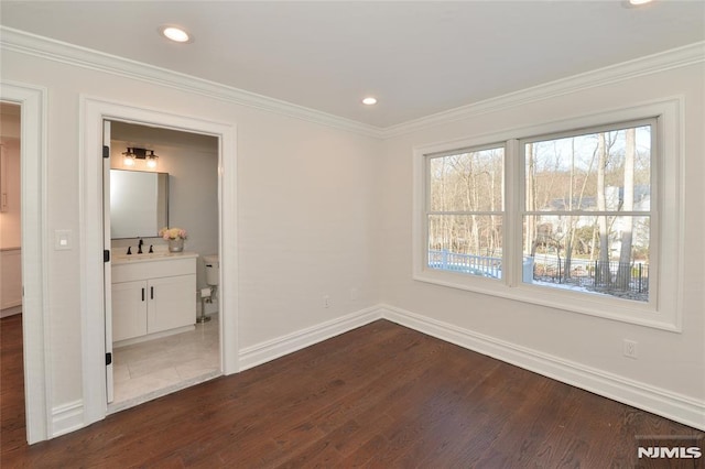 empty room featuring sink, ornamental molding, and dark hardwood / wood-style floors