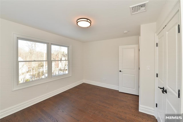 unfurnished room with dark hardwood / wood-style flooring