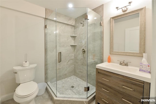 bathroom with vanity, a shower with door, and toilet