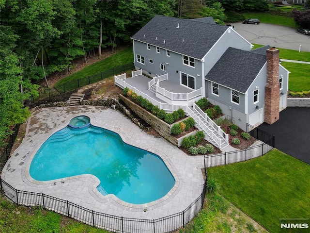 view of pool featuring an in ground hot tub, a lawn, a deck, and a patio area