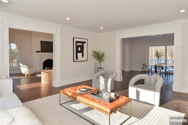 living room with crown molding, plenty of natural light, and dark hardwood / wood-style floors