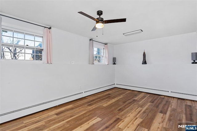 empty room with ceiling fan, wood-type flooring, ornamental molding, and a baseboard radiator