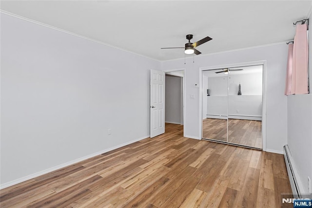 unfurnished bedroom with ceiling fan, baseboard heating, ornamental molding, light hardwood / wood-style floors, and a closet