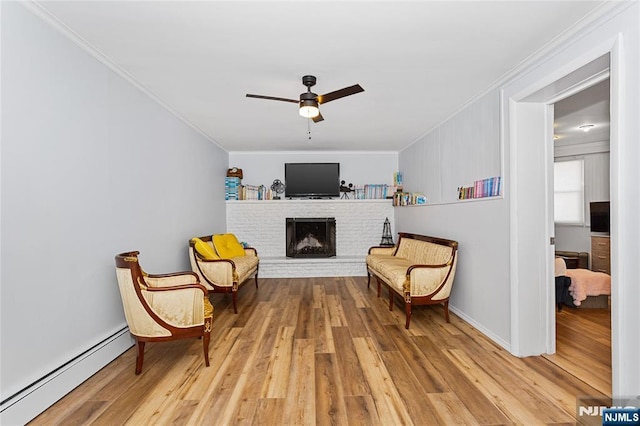 sitting room featuring hardwood / wood-style flooring, ornamental molding, and a baseboard heating unit