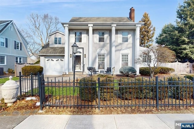 neoclassical / greek revival house featuring a garage