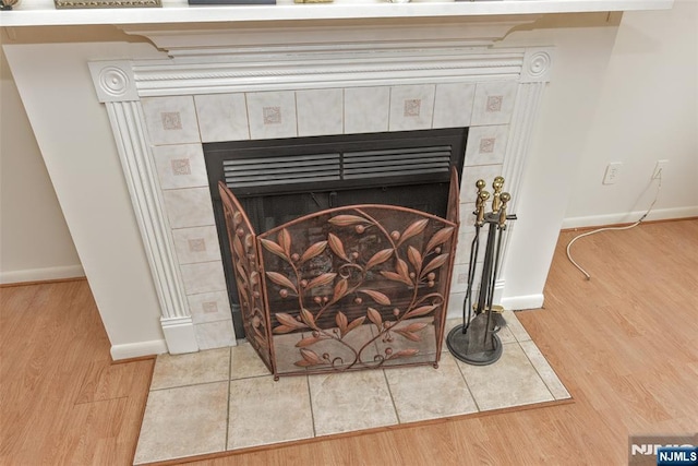 details with a tile fireplace and hardwood / wood-style floors