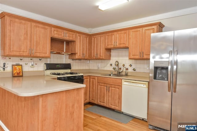 kitchen with sink, decorative backsplash, kitchen peninsula, white appliances, and light hardwood / wood-style flooring