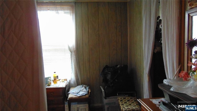 bedroom with wooden walls and multiple windows