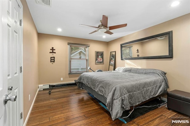 bedroom with dark wood-type flooring, ceiling fan, a closet, and a baseboard heating unit