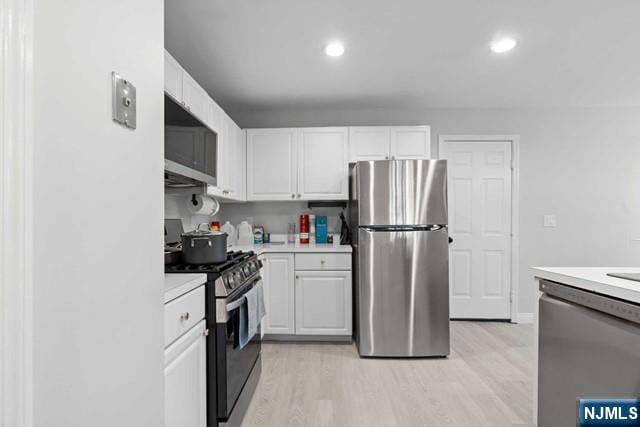 kitchen featuring white cabinetry, light wood-type flooring, and appliances with stainless steel finishes