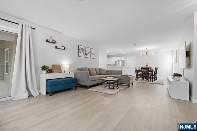 living room with a chandelier and light hardwood / wood-style floors