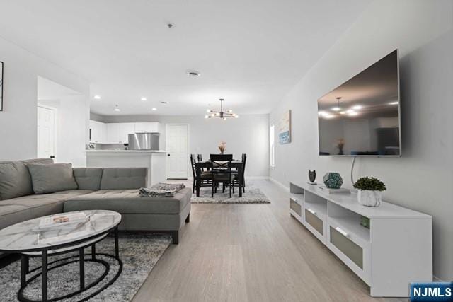 living room featuring an inviting chandelier and light hardwood / wood-style flooring