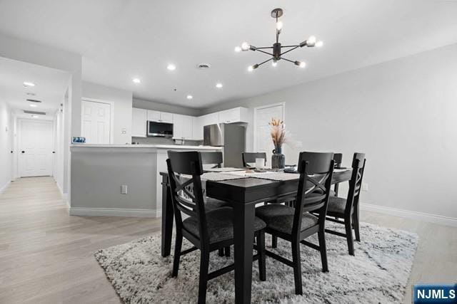 dining room featuring a notable chandelier and light wood-type flooring