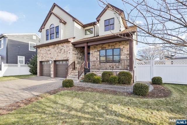 view of front of house featuring a garage, a front yard, and covered porch