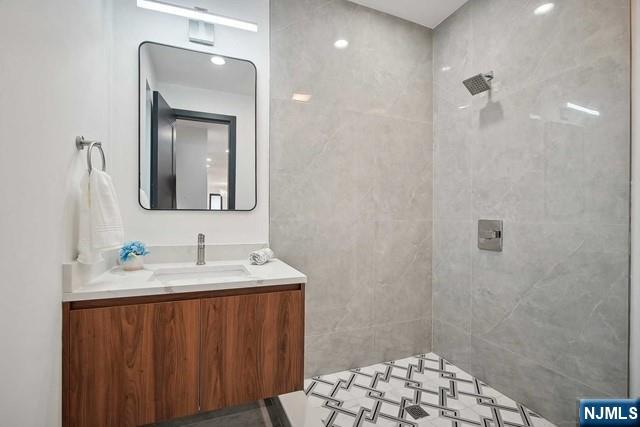 bathroom featuring vanity and a tile shower