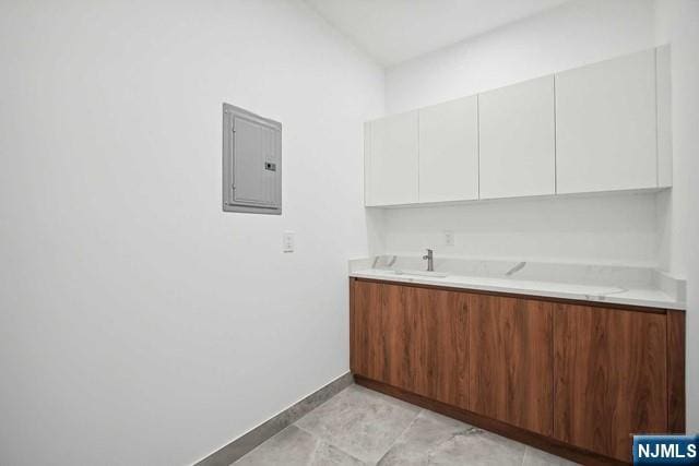 kitchen with sink, white cabinets, and electric panel