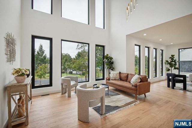 living room featuring a high ceiling and light hardwood / wood-style floors