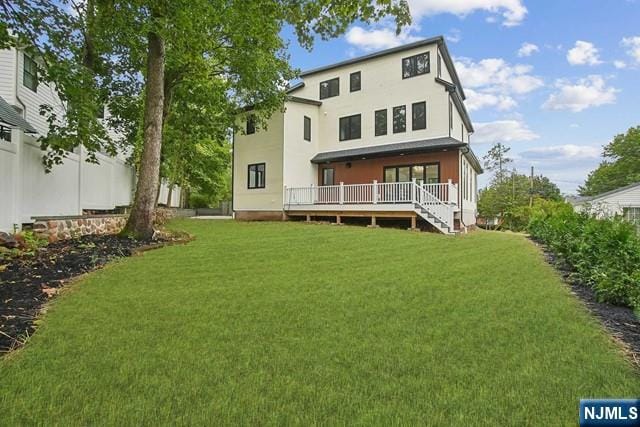 back of house with a wooden deck and a yard