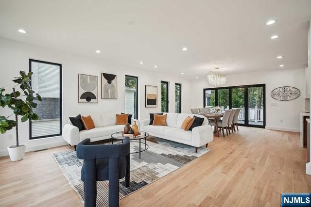 living room with a chandelier and light hardwood / wood-style floors