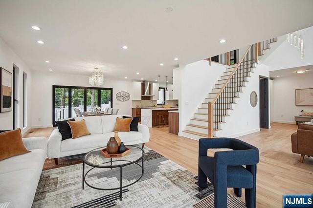 living room featuring a notable chandelier and light hardwood / wood-style flooring