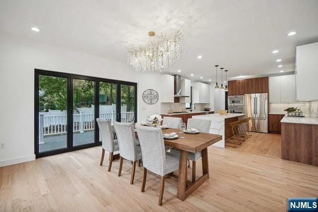 dining room with an inviting chandelier and light hardwood / wood-style floors