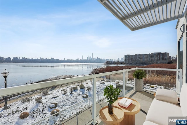 balcony with a water view and a pergola