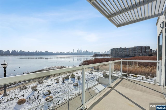 balcony featuring a water view and a pergola