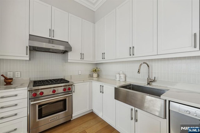 kitchen featuring premium range, sink, dishwasher, light stone countertops, and white cabinets