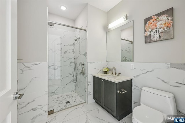 bathroom with vanity, a shower with door, tile walls, and toilet