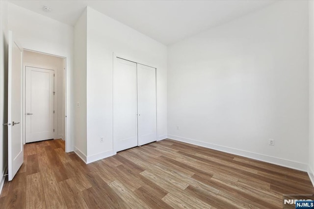 unfurnished bedroom with hardwood / wood-style floors and a closet