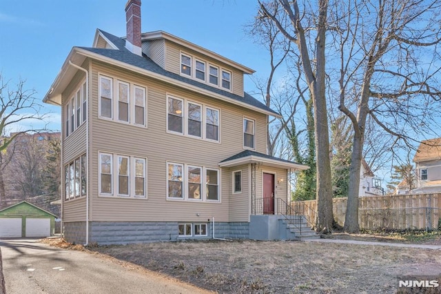 view of front of house with a garage and an outdoor structure