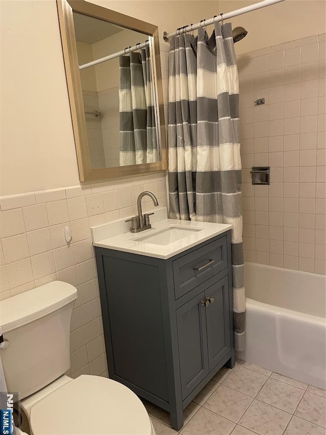 full bathroom with tile walls, tile patterned flooring, vanity, toilet, and shower / bath combo with shower curtain