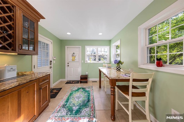 dining space with a wealth of natural light and light tile patterned flooring