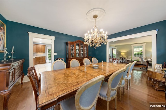 dining space featuring a notable chandelier and light wood-type flooring