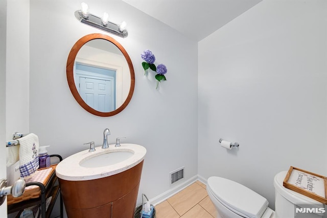 bathroom featuring vanity, tile patterned floors, and toilet