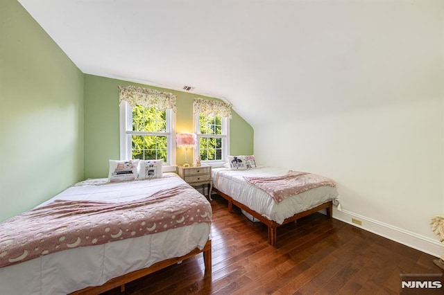 bedroom with vaulted ceiling and dark hardwood / wood-style floors