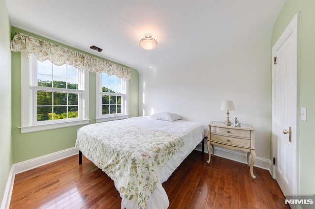 bedroom with dark wood-type flooring