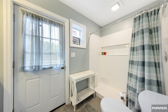 bathroom with toilet and walk in shower