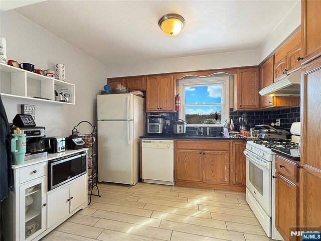 kitchen featuring sink, white appliances, and decorative backsplash