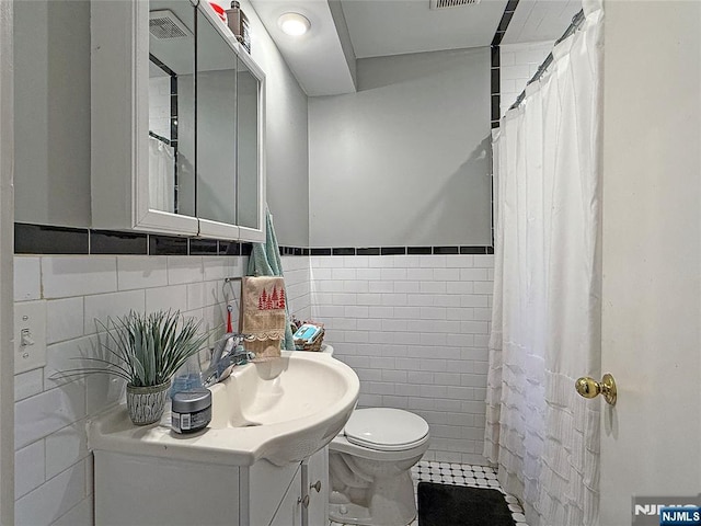 bathroom with a shower with curtain, vanity, tile walls, and toilet