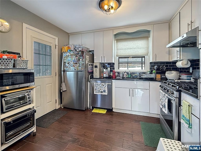 kitchen with dark hardwood / wood-style floors, sink, white cabinets, backsplash, and stainless steel appliances