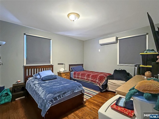 bedroom featuring a wall mounted air conditioner and dark hardwood / wood-style floors